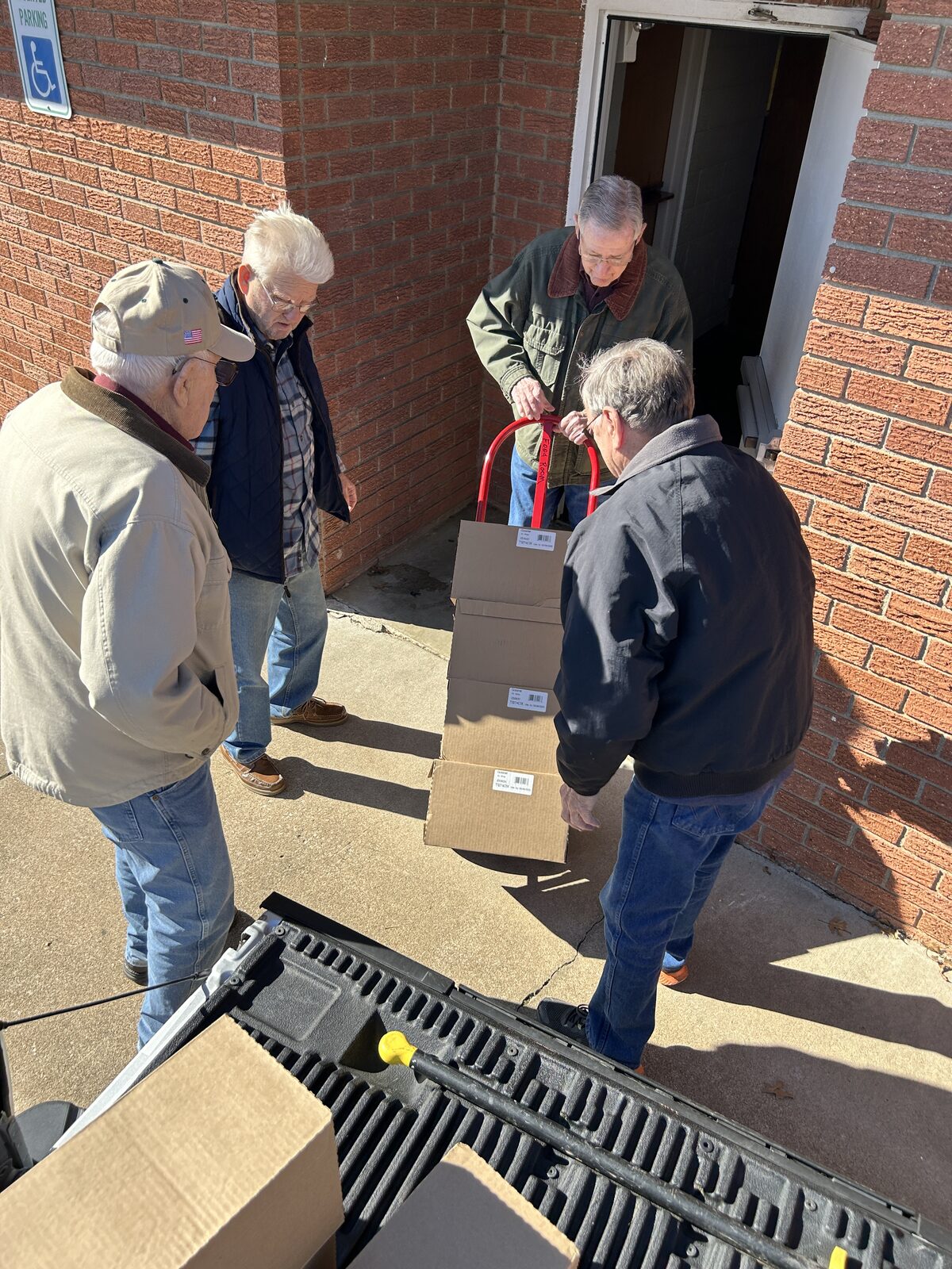 Volunteers wheel boxes of donated food into the Blue Starr pantry food room on a hand truck