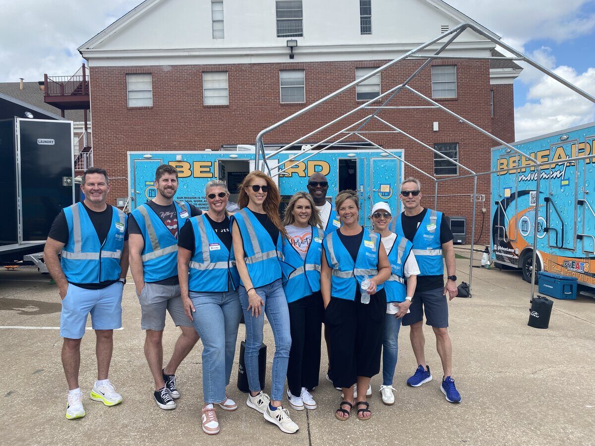 A corporate volunteer team in Serve.Love check-in vests at a community serve day